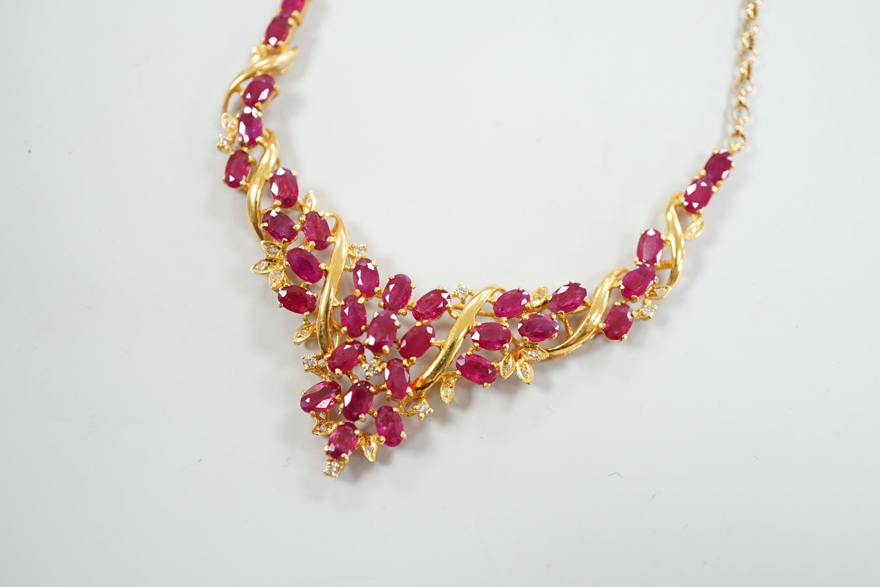 A 20th century Indian yellow metal, ruby and diamond chip cluster set necklace, with later 375 chain, 52cm, gross weight 12.2 grams.